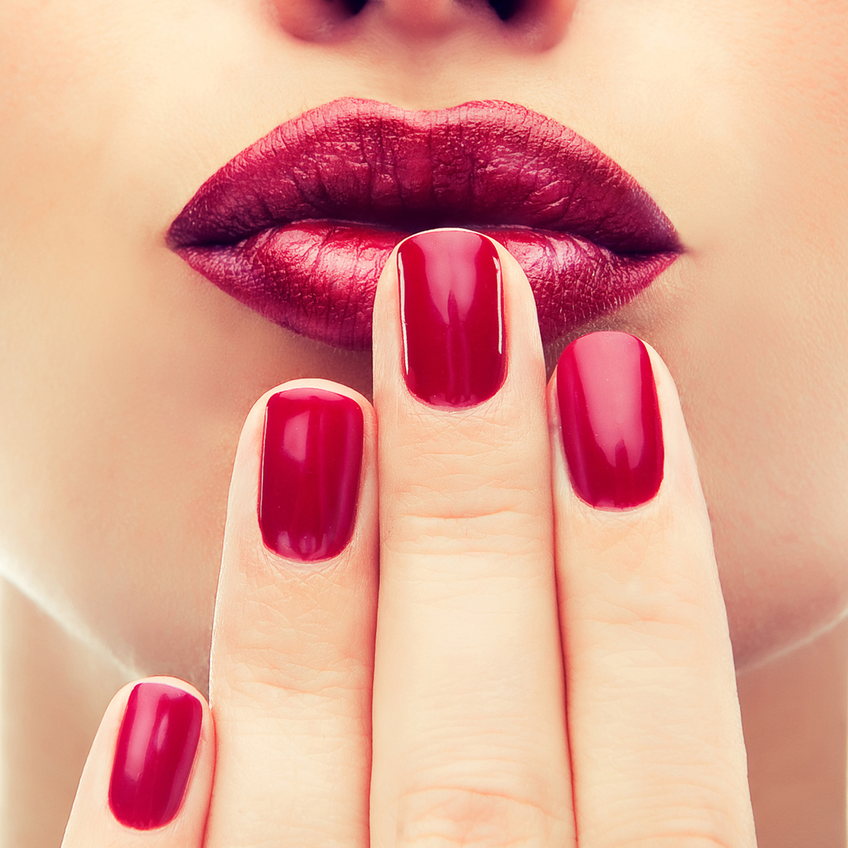 Beautiful model shows red manicure on nails. Red lips .Luxury